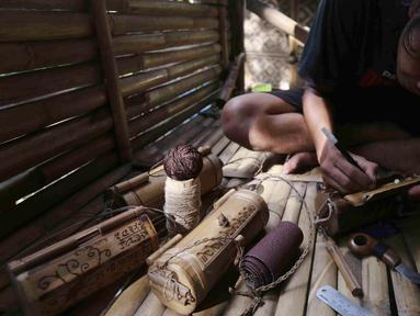 Perajin membuat kerajinan tas dari limbah bambu di Grand Depok City, Depok, Jawa Barat, Kamis (2/6/2022). Komunitas Ciliwung Depok (KCD) memanfaatkan limbah bambu yang berada di Sungai Ciliwung menjadi kerajinan seperti tas, tempat alat tulis, dan cangkir. (Liputan6.com/Herman Zakharia)