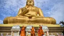 Biksu Buddha berjalan mengelilingi patung Buddha raksasa saat mereka melakukan ritual keagamaan untuk menandai Hari Makha Bucha di kota Narathiwat, Thailand selatan  (6/3/2023). Makha Bucha merupakan salah satu hari raya terpenting bagi para penganut agama Buddha. (AFP/Madaree Tohlala)