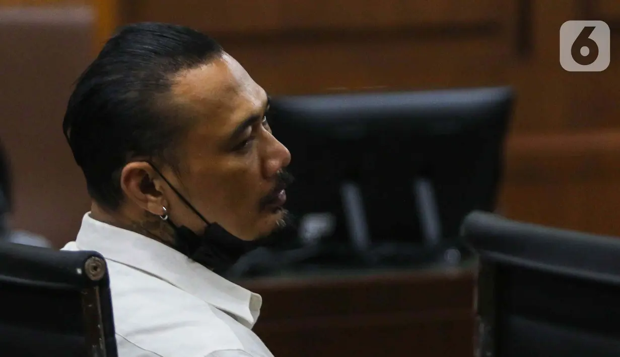 Terdakwa musisi I gede Ari Astina atau Jerinx mengikuti sidang tuntutan di PN Jakarta Pusat, Jakarta, Jumat (18/2/2022). Jerinx dituntut dua tahun penjara dan denda Rp50 juta subsider dua bulan kurungan atas kasus dugaan pengancaman kepada Adam Deni. (Liputan6.com/Herman Zakharia)