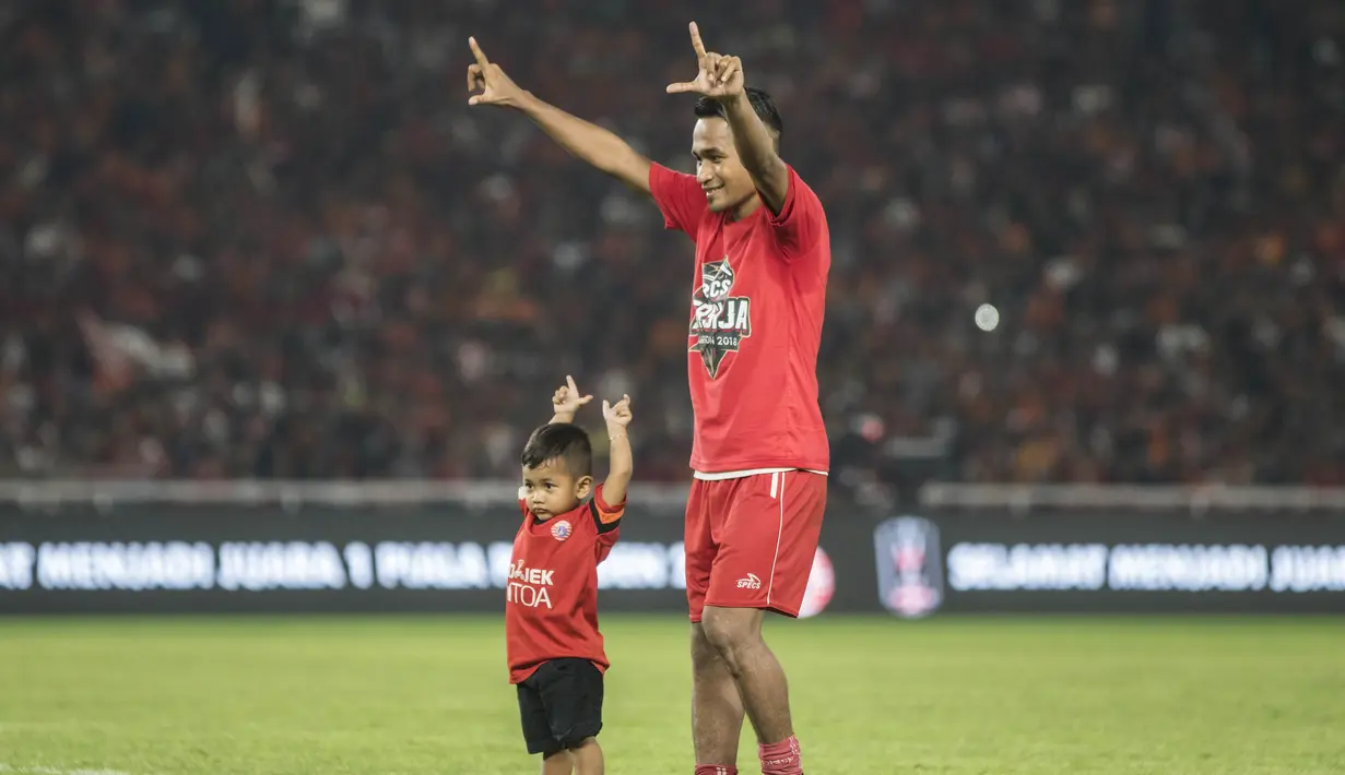 Gelandang Persija Jakarta, Ramdani Lestaluhu, mengajak sang anak menyapa suporter merayakan gelar juara Piala Presiden di SUGBK, Jakarta, Sabtu (17/2/2018). Persija menang 2-0 atas Bali United. (Bola.com/Vitalis Yogi Trisna)