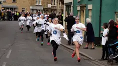 Para peserta bersaing dalam lomba lari sembari membawa wajan berisi pancake di Kota Olney, Buckinghamshire, Inggris, Selasa (28/2). Tidak hanya membawa wajan, peserta juga harus membolak-balikan pancake sambil tetap berlari.  (AP Photo/Alastair Grant)