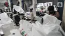Pekerja menyelesaikan pembuatan baju hazmat di salah satu industri konveksi Pusat Industri Kecil (PIK), Jakarta, Rabu (30/12/2020). Budi (48), seorang marketing di Toko Konveksi Baju, mengungkapkan permintaan baju hazmat hingga kini masih tinggi. (merdeka.com/Iqbal S. Nugroho)