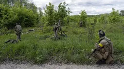 Prajurit Ukraina didampingi anggota legiun asing menembakkan mortir ke posisi Rusia di wilayah Kharkiv, Ukraina, 17 Mei 2022. (AP Photo/Bernat Armangue)