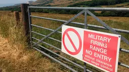 Tanda dari Menteri Pertahanan Inggris yang memperingatkan pengunjung bahwa mereka berada di jarak tembak dekat Dorset, Inggris, 8 Juli 2018. Tyneham berada di tangan militer sejak 1943 hingga saat ini. (AP Photo/Jerry Harmer)