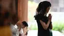 Umat Katolik berdoa mengenang Paus Fransiskus di Gereja Holy Redeemer di Bangkok, Thailand pada 21 April 2025. (Lillian SUWANRUMPHA/AFP)