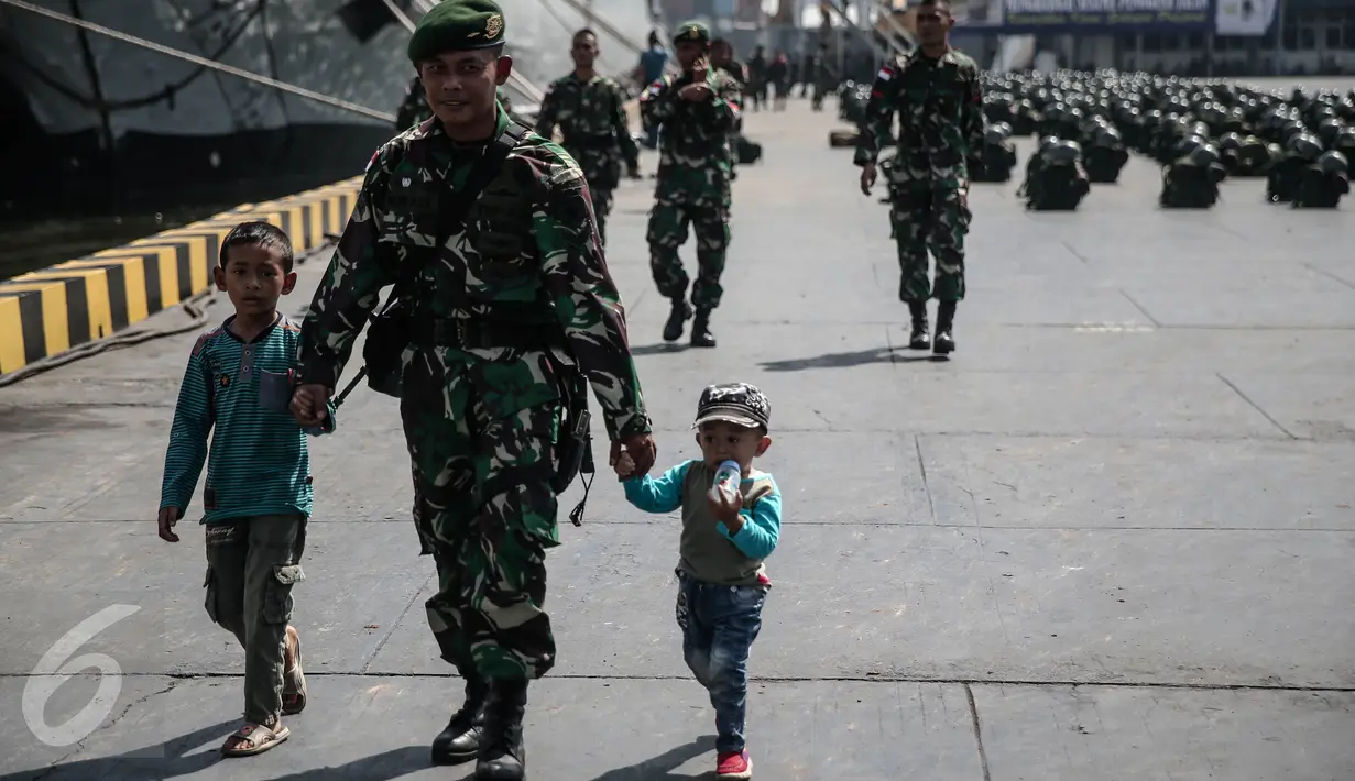 Seorang personel TNI-AD menggandeng dua anaknya di Pelabuhan Kolinlamil, Jakarta, Senin (9/5). Sebanyak 450 personel TNI-AD dari Satgas Yonif Para Raider 330 inf 1 Kostrad dilepas untuk misi pengamanan perbatasan RI-PNG. (Liputan6.com/Faizal Fanani)