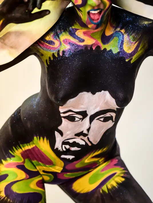 Seorang model menunjukkan tubuhnya yang telah dilukis selama pameran body painting, Santiago (24/11/2015). Lebih dari 100 desain yang terinspirasi oleh ikon musik, dipamerkan dalam pameran tersebut (AFP Photo/Martin Bernetti)