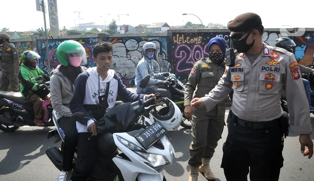 Polisi memberhentikan pengendara sepeda motor yang tidak mengenakan masker di kawasan Jalan Ir. H. Juanda, Depok, Jawa Barat, Kamis (23/7/2020). Razia tersebut dilakukan oleh tim gabungan dari Polresta Depok dan Satpol PP. (merdeka.com/Arie Basuki)
