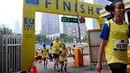 Peserta melewati garis finish ketika mengikuti lomba lari bertajuk 'EU On The Move 5K' di Sudirman, Jakarta, Minggu (3/5). Acara tersebut memulai garis start di Sampoerna Strategic Square dan finish di Menara Intiland. (Liputan6.com/Yoppy Renato)