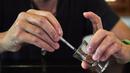 Steve Ludwin memindahkan bisa ular viper palem ke dalam jarum suntik untuk digunakan olehnya, di Kennington, London, Kamis (9/11). Steve Ludwin sudah hampir 30 tahun menyuntikkan bisa ular viper tersebut ke tubuhnya. (AFP Photo/Niklas Halle'n)