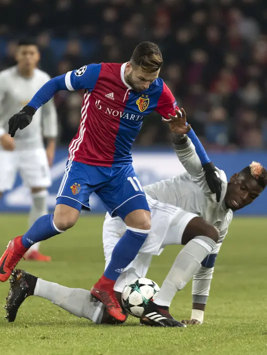 Pemain Basel, Renato Steffen (kiri) berebut bola dengan pemain Manchester United, Paul Pogba pada laga grup A Liga Champions di St. Jakob-Park stadium, Basel, Swiss, (22/11/2017). MU kalah 0-1 dari Basel. (Georgios Kefalas/Keystone via AP)