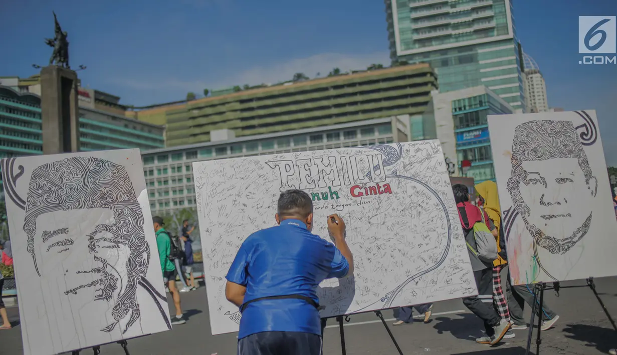 Masyarakat menandatangani dilukisan capres 01 dan 02  yang bertema ‘ Pemilu Penuh Cinta’  saat Car Free day di kawasan Bundaran HI, Jakarta, MInggu (14/4). Kampanye tersebut untuk mengajak masyarakat untuk berpartisipasi dalam Pemilu secara Damai. (Liputan6.com/Faizal Fanani)