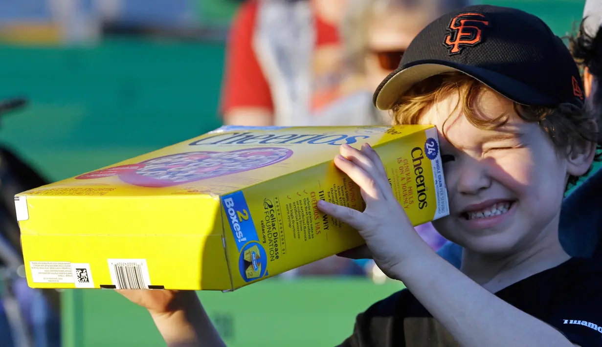 Griffin O'Roak melihat fenomena gerhana matahari dengan alat buatannya sendiri di Salem, Oregon,Senin (21/8). Sebagian warga Amerika Serikat menyambut fenomena langka ini dengan berbagai cara yang unik. (AP Photo/Don Ryan)