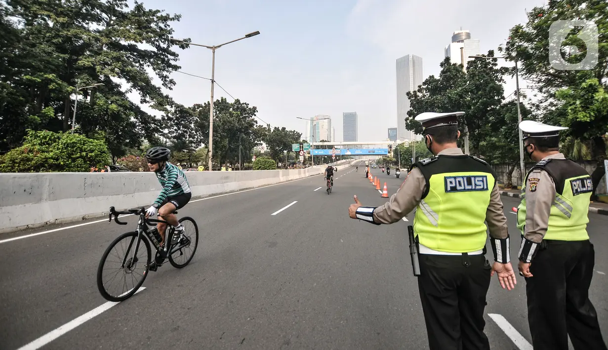 Petugas Dishub dan kepolisian saat menjaga jalannya uji coba lintasan Road Bike di JLNT Kampung Melayu-Tanah Abang, Jakarta, Minggu (23/5/2021). Uji coba lintasan Road Bike tersebut sebagai langkah untuk memfasilitasi arena bagi para pesepeda balap di Ibu Kota. (merdeka.com/Iqbal S Nugroho)