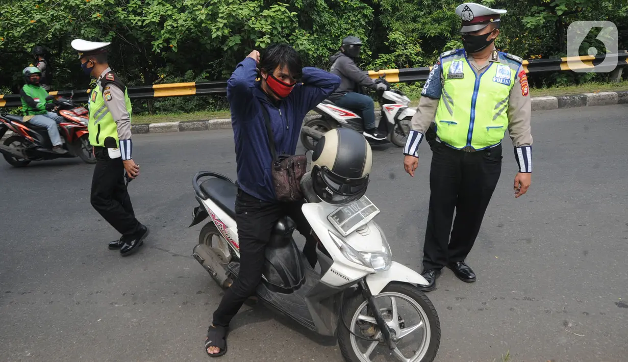 Petugas gabungan memberhentikan pengendara motor yang tidak memakai masker saat penyekatan kendaraan menuju Jakarta di Kelapa Dua, Jagakarsa, Jakarta Selatan, Rabu (27/05/2020). Pemprov DKI Jakarta menerapkan pengetatan bagi para calon pendatang usai mudik Lebaran 2020. (merdeka.com/Arie Basuki)