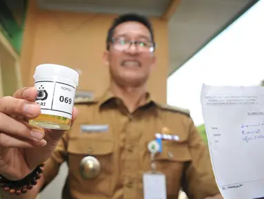 Seorang pegawai menunjukkan sampel urine saat pemeriksaan di Kecamatan Larangan, Ciledug, Tangerang, Senin (25/4).  Sekitar 130 PNS dan non PNS se Kecamatan Larangan dites urine untuk mengantisipasi penyalahgunaan narkoba. (Liputan6.com/Gempur M Surya)
