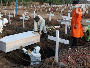 Petugas melakukan pemakaman jenazah dengan protokol COVID-19 di TPU Khusus COVID-19 Rorotan, Jakarta, Rabu (11/8/2021). Pemerintah menghapus data angka kematian dari indikator penanganan COVID-19. Pemerintah beralasan terjadi permasalahan input data angka kematian, (Liputan6.com/Helmi Fithriansyah)