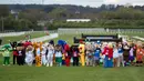 Sejumlah orang mengenakan kostum badut berpose untuk befoto bersama sebelum mengikuti Mascot Gold Cup tahunan ke-13 di Wetherby Racecourse, Inggirs (29/4). (AFP/Oli Scarff)