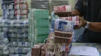Petugas tengah mengepakan mata uang rupiah di kantor Cash BNI, Jakarta, Jumat (17/6). Kebutuhan uang tunai di ATM dan outlet diperkirakan mencapai lebih dari Rp 62 triliun, naik 8% dari realisasi tahun sebelumnya. (Liputan6.com/ Angga Yuniar)