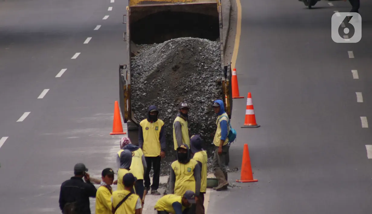 Pekerja melakukan penataan di ruas jalan nasional di Jalan Daan Mogot, Kota Tangerang, Banten, Selasa (15/2/2022). Pemkot Tangerang berencana melakukan sistem satu arah di Jalan Daan Mogot untuk mengatasi kemacetan di akses masuk tol Cengkareng-Batu Ceper-Kunciran. (Liputan6.com/Angga Yuniar)