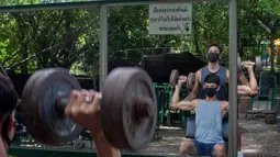 Sejumlah pria berolahraga di gym luar ruangan di sebuah taman di Bangkok, Thailand, Rabu (10/6/2020). Kehidupan sehari-hari di ibukota kembali normal karena pemerintah Thailand terus melonggarkan pembatasan terkait dengan menjalankan bisnis di ibukota Bangkok. (AP Photo/Gemunu Amarasinghe)