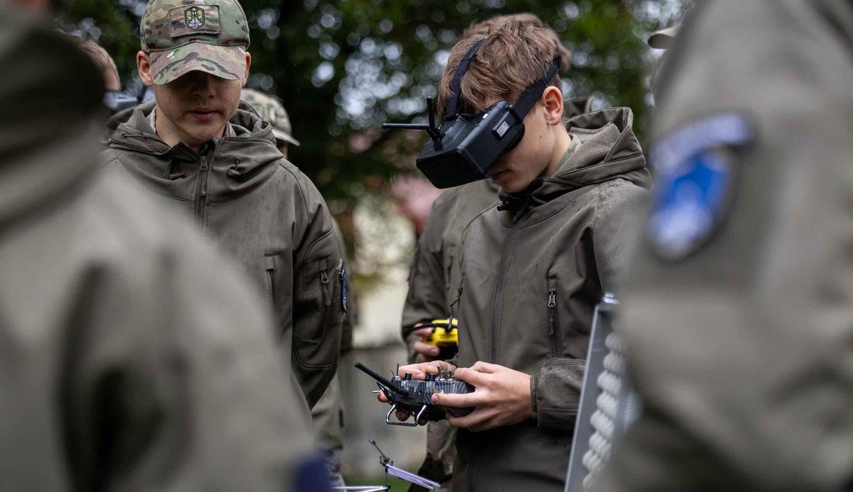 Seorang mahasiswa bernama Bartosz Ladocha mengenakan kacamata khusus untuk mengendalikan drone FPV (first-person-view) saat mengikuti kursus drone di Sekolah Militer, Legnica, Polandia Barat, pada 8 Oktober 2025. (Wojtek RADWANSKI/AFP)