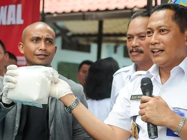 Kepala BNN Budi Waseso dan Ivan Slank menunjukan barang bukti narkotika yang akan dimusnahkan di Kantor BNN, Jakarta, Kamis (18/5). Barang bukti yang didapat dari hasil tujuh kasus yang berbeda selama Maret hingga Mei 2017. (Liputan6.com/Yoppy Renato)