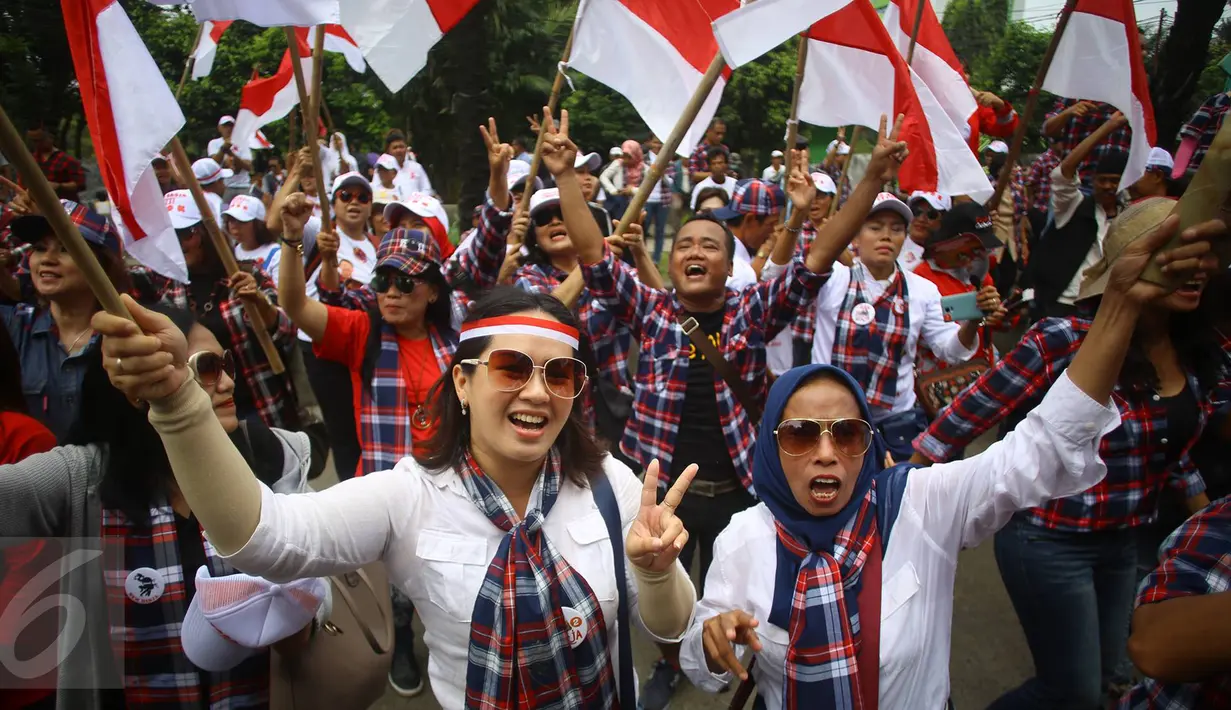 Pendukung Cagub DKI Basuki T Purnama meneriakkan yel di luar ruang sidang kasus penistaan agama, Jakarta, Selasa (10/1). Dengan mengenakan atribut kotak-kotak, massa membawa bendera Indonesia serta melakukan orasi damai. (Liputan6.com/Immanuel Antonius)