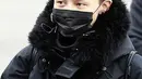 Ia mengenakan penutup kepala, masker, dan mantel serba hitam. G-Dragon menyempurnakan penampilannya dengan sepatu kets warna ungu. (Foto: whatthekpop.com)