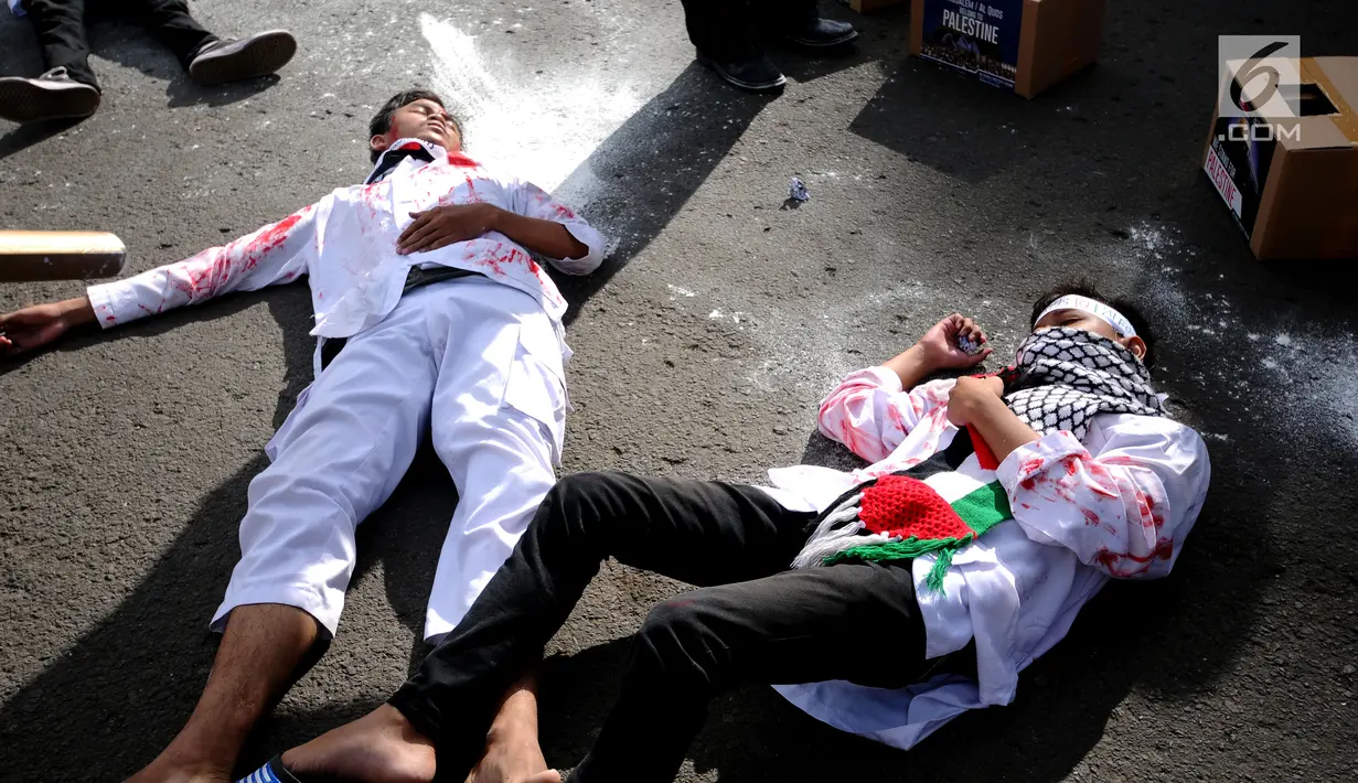 Peserta aksi melakukan teatrikal tentang kekejaman tentara Israel di kawasan Bundaran HI, Jakarta, Minggu (10/12). Mereka memprotes keputusan Presiden AS Donald Trump yang mengakui Yerusalem sebagai Ibu Kota Israel. (Liputan6.com/Helmi Fithriansyah)