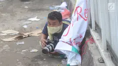 Jurnalis melindungi dirinya saat meliput demontrasi yang memanas di depan gedung Dewan Perwakilan Rakyat (DPR), Senayan, Jakarta, Selasa (24/9/2019). Polisi menembakkan gas air mata dan meriam air untuk membubarkan massa aksi yang menolak RKUHP dan RUU kontroversial lain. (merdeka.com/Arie Basuki)
