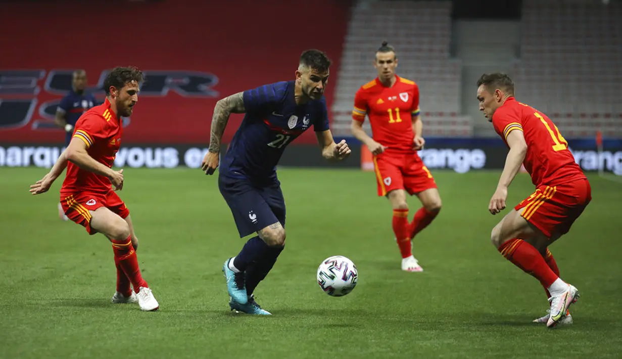 Pemain Prancis Lucas Hernandez (tengah) mengontrol bola melewati pemain Wales Connor Roberts (kanan) pada pertandingan persahabatan di Stadion Allianz Riviera, Nice, Prancis, Rabu (2/6/2021). Prancis membantai Wales 3-0. (AP Photo/Daniel Cole)