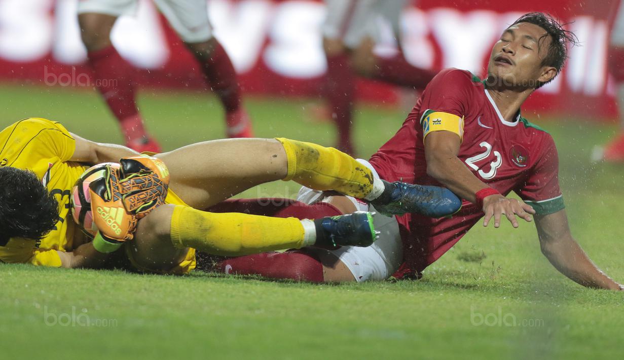 Kapten Timnas Indonesia U-23, Hansamu Yama berebut bola dengan kiper Suriah U-23 pada laga persahabatan di Stadion Wibawa Mukti, Bekasi, Rabu (16/11/2017). Indonesia kalah 2-3. (Bola.com/NIcklas Hanoatubun)