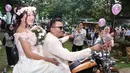Setelah keliling dengan motor gede, keduanya pun melepas burung merpati dan balon dengan para undangan. Setelah itu, mereka pun langsung naik ke pelaminan dengan diiringi keluarga besar. (Nurwahyunan/Bintang.com)
