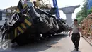 Petugas kepolisian mengevakuasi crane yang jatuh di Jalan Kyai Maja, Jakarta Selatan, Kamis (15/10/2015). Alat besar yang tengah melakukan proyek ‎jalan layang ini menimpa salah satu rumah warga yang berada di sisi kanan jalan. (Liputan6.com/Helmi Afandi)