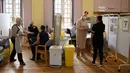 Orang-orang menunggu untuk menerima dosis vaksin COVID-19 Moderna di Rumah Sakit Babington, Belper, Inggris, 16 Desember 2021. Inggris melaporkan rekor COVID-19 baru mencapai 88.376 kasus dalam 24 jam pada 16 Desember 2021, pecahkan rekor sehari sebelumnya yaitu 78.610 kasus. (Oli SCARFF/AFP)