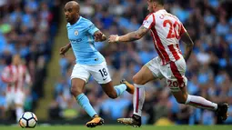 Gelandang Manchester City, Fabian Delph berusaha membawa bola dari kawalan pemain Stoke City, Geoff Cameron saat bertanding pada lanjutan Liga Inggris di Etihad Stadium, Manchester, (14/10). City menang 7-2 atas Stoke. (Mike Egerton / PA via AP)