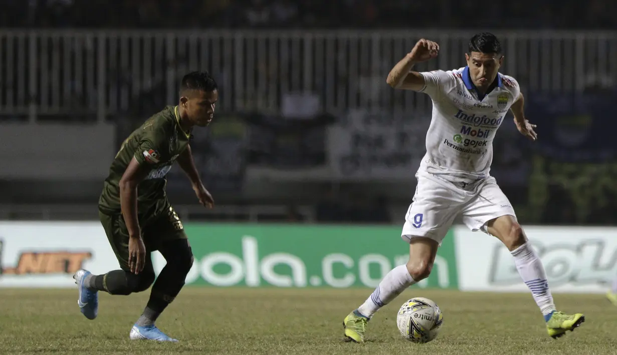 Gelandang Persib Bandung, Esteban Vizcarra, berebut bola dengan gelandang Tira Persikabo, Manahati Lestusen, pada laga Shopee Liga 1 di Stadion Pakansari, Bogor, Sabtu (14/9). Tira Persikabo bermain imbang 1-1 atas Persib Bandung. (Bola.com/Yoppy Renato)