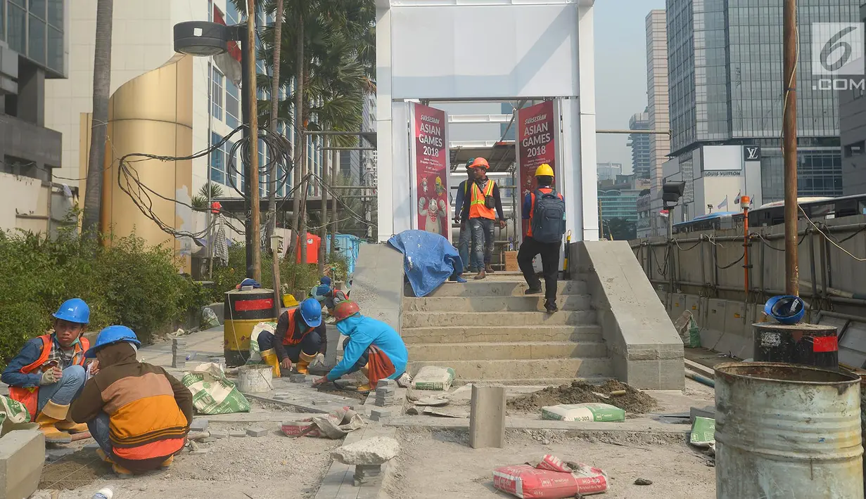 Pekerja menyelesaikan proyek pembangunan trotoar di Jalan MH Thamrin,Jakarta,Kamis (19/7). Pengecatan trotoar di Jalan Sudirman - MH Thamrin dimulai pada 18 Juli - 12 Agustus 2018. (Merdeka.com/Imam Buhori)