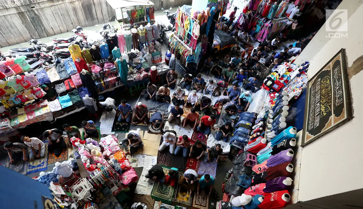 Umat muslim melakukan salat Jumat diantara kios-kios Pedagang Tanah Abang, Jakarta, Jumat (9/6). Dikarenakan membeludaknya jamaah yang ingin beribadah mereka terpaksa melakukan salat di antara kios-kios pasar. (Liputan6.com/Johan Tallo)