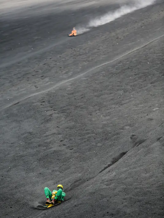 Keseruan wisatawan bermain sandboarding atau berseluncur pasir menuruni gunung berapi Cerro Negro di Leon, Nikaragua, 24 September 2016. Gunung Cerro Negro salah satu gunung api yang masih aktif di Nikaragua. (INTI Ocon/AFP)