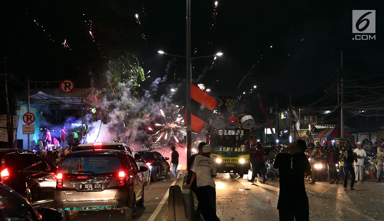 Warga menyalakan kembang api di tengah pawai untuk memeriahkan malam takbiran di sepanjang Jalan Mas Mansyur, Tanah Abang, Jakarta Pusat, Kamis (14/6) malam. (Liputan6.com/Johan Tallo)