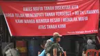Seorang ibu menggendong anaknya berjalan di depan spanduk penolakan di kawasan jalan Mangga Besar, Jakarta, Senin (22/8). Spanduk itu dipasang warga RW2 Kelurahan Mangga Besar sebagai aksi menolak penggusuran rumah mereka. (Liputan6.com/Gempur M Surya)