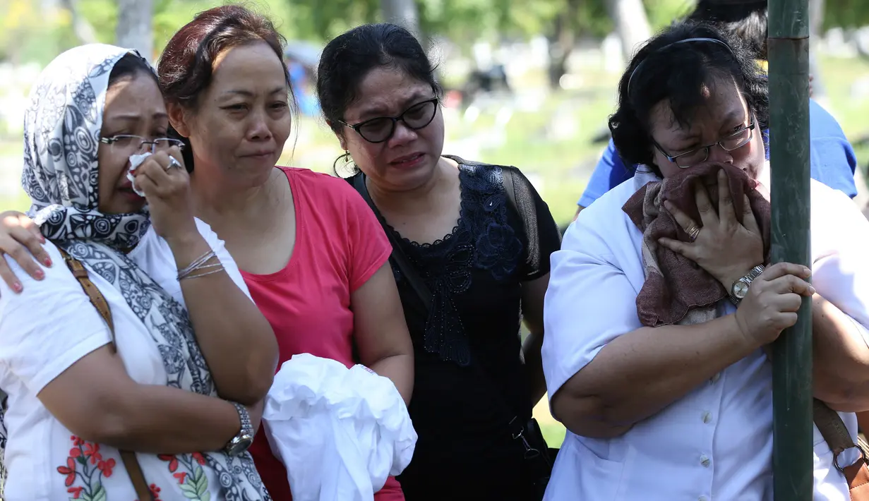 Suasana haru mewarnai pemakaman korban bom gereja Surabaya, Martha Djumani di komplek Taman Makam Keputih, Surabaya, Rabu (16/5). Martha merupakan salah satu korban bom bunuh diri di Gereja Pantekosta Pusat Surabaya Minggu (13/5) lalu. (AP/Achmad Ibrahim)