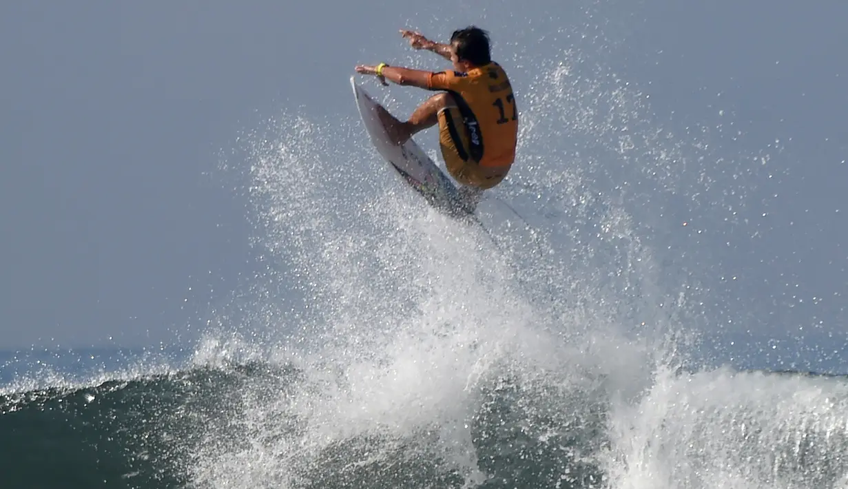 Julian Wilson dari Australia melompati ombak besar dengan papannya selama bertanding dalam turnamen Kejuaraan Selancar Dunia 2018 di Keramas, Gianyar, di pulau resor Bali (31/5). (AFP Photo/Sonny Tumbelaka)
