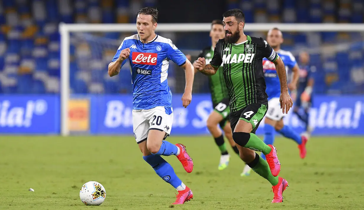 Pemain Napoli, Piotr Zielinski, berebut bola dengan pemain Sassuolo, Francesco Manganelli, pada laga Serie A di Stadion San Paolo Sabtu (25/7/2020). Napoli menang 2-0 atas Sassuolo. (Cafaro/LaPresse via AP)