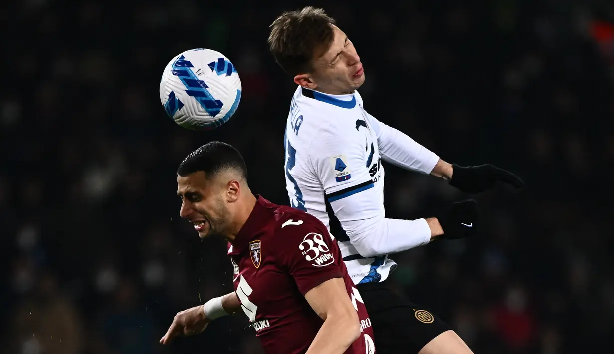 Gelandang Torino, Rolando Mandragora (kiri) dan gelandang Inter Milan Nicolo Barella berebut bola udara pada pertandingan lanjutan Liga Serie A Italia di stadion Olimpiade di Turin, Senin (14/3/2022). Dengan hasil ini Inter Milan turun ke peringkat ketiga dengan 59 poin. (AFP/Marco Bertorello)