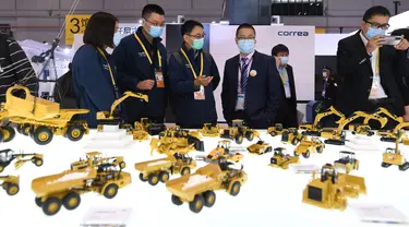 Para peserta pameran memperkenalkan kendaraan teknik di stan Caterpillar di area ekshibisi Peralatan dalam Pameran Impor Internasional China (China International Import Expo/CIIE) ketiga di Shanghai, China timur, pada 5 November 2020. (Xinhua/Li Renzi)