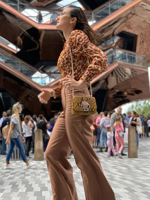 Luna Maya juga terlihat mengenakan blouse panthera chiffon bermotif panther warna coklat yang dipadukan dengan flare pants heather basket weave dengan warna senada dari Kate Spade. (Liputan6.com/IG/@lunamaya)