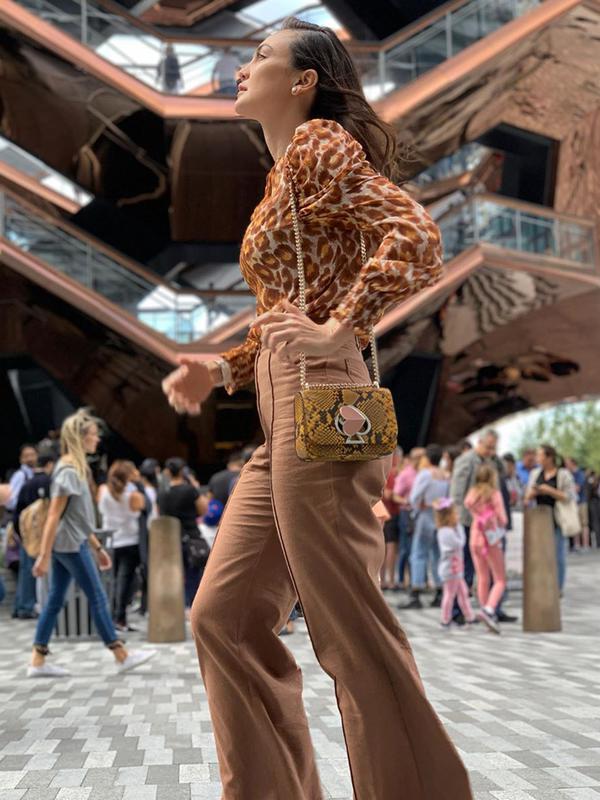 Luna Maya juga terlihat mengenakan blouse panthera chiffon bermotif panther warna coklat yang dipadukan dengan flare pants heather basket weave dengan warna senada dari Kate Spade. (Liputan6.com/IG/@lunamaya)